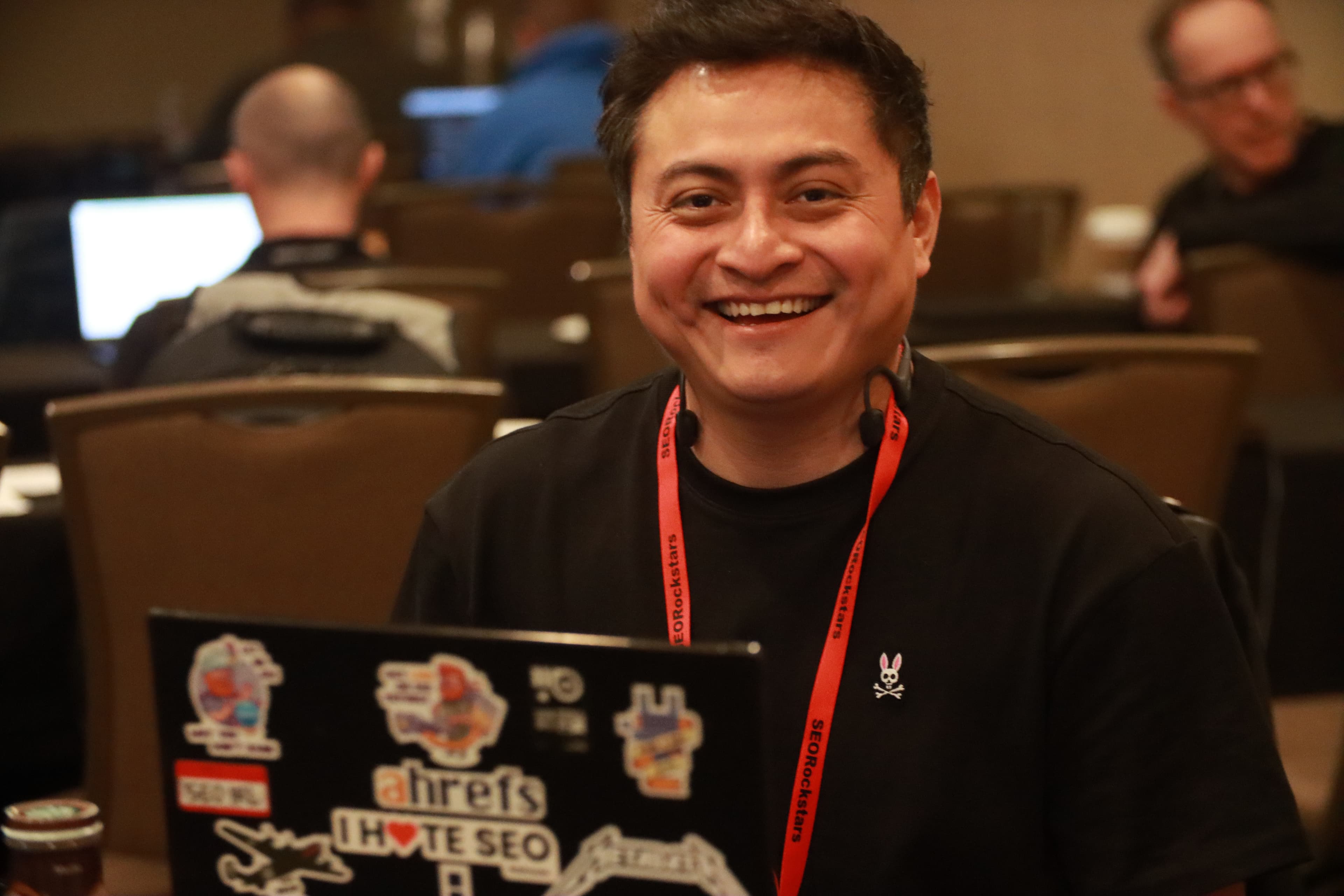 Attendee giving thumbs up with SEO stickers on laptop